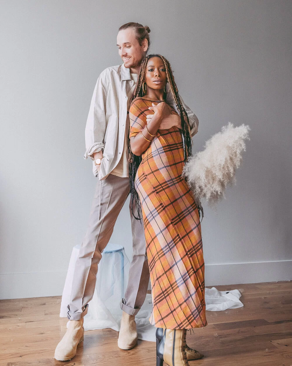 Men and a woman standing in linen outfits