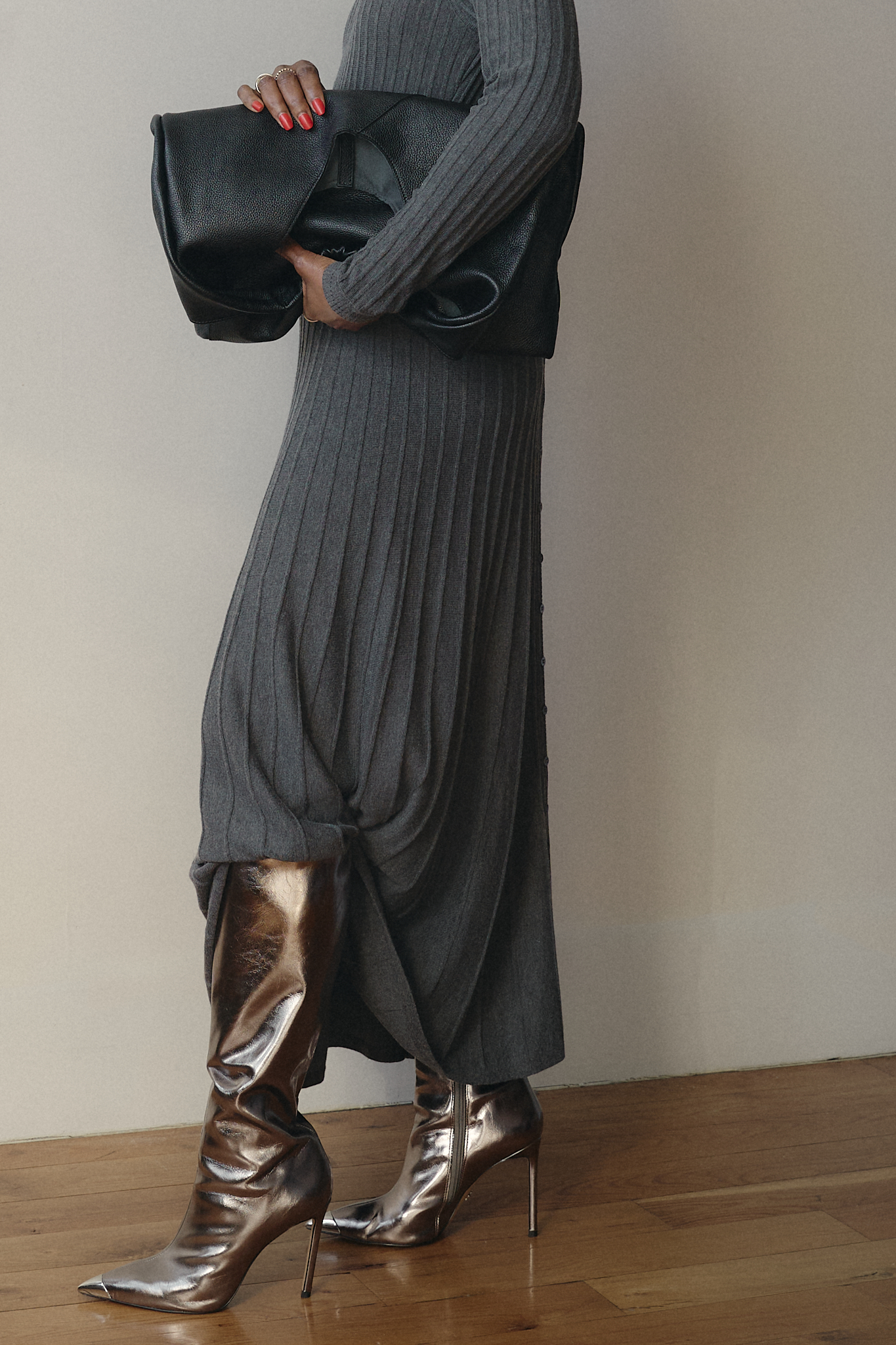 Chic fall outfit featuring a grey ribbed knit long-sleeve dress, silver stiletto boots, and a black oversized clutch — modern minimalist fashion for colder seasons.